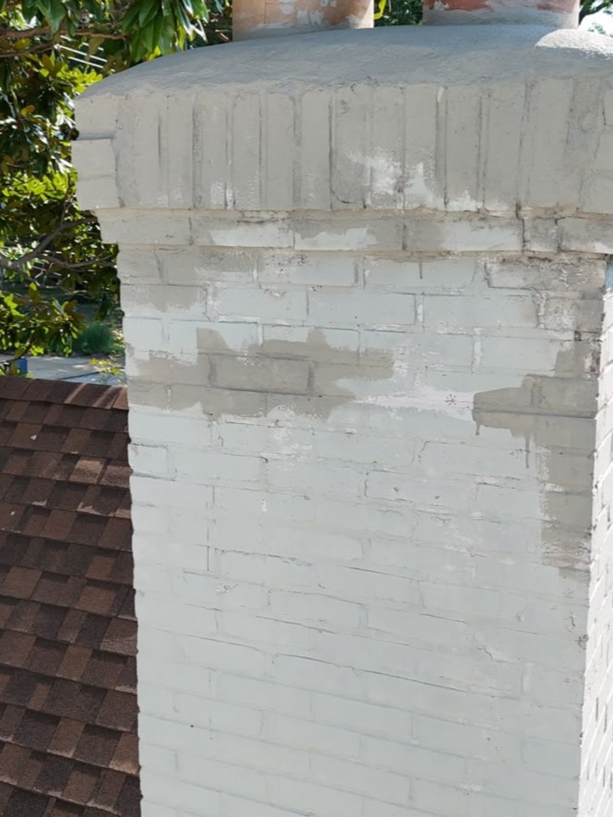 Top of the chimney showing patch repairs in several different colours under the old crown