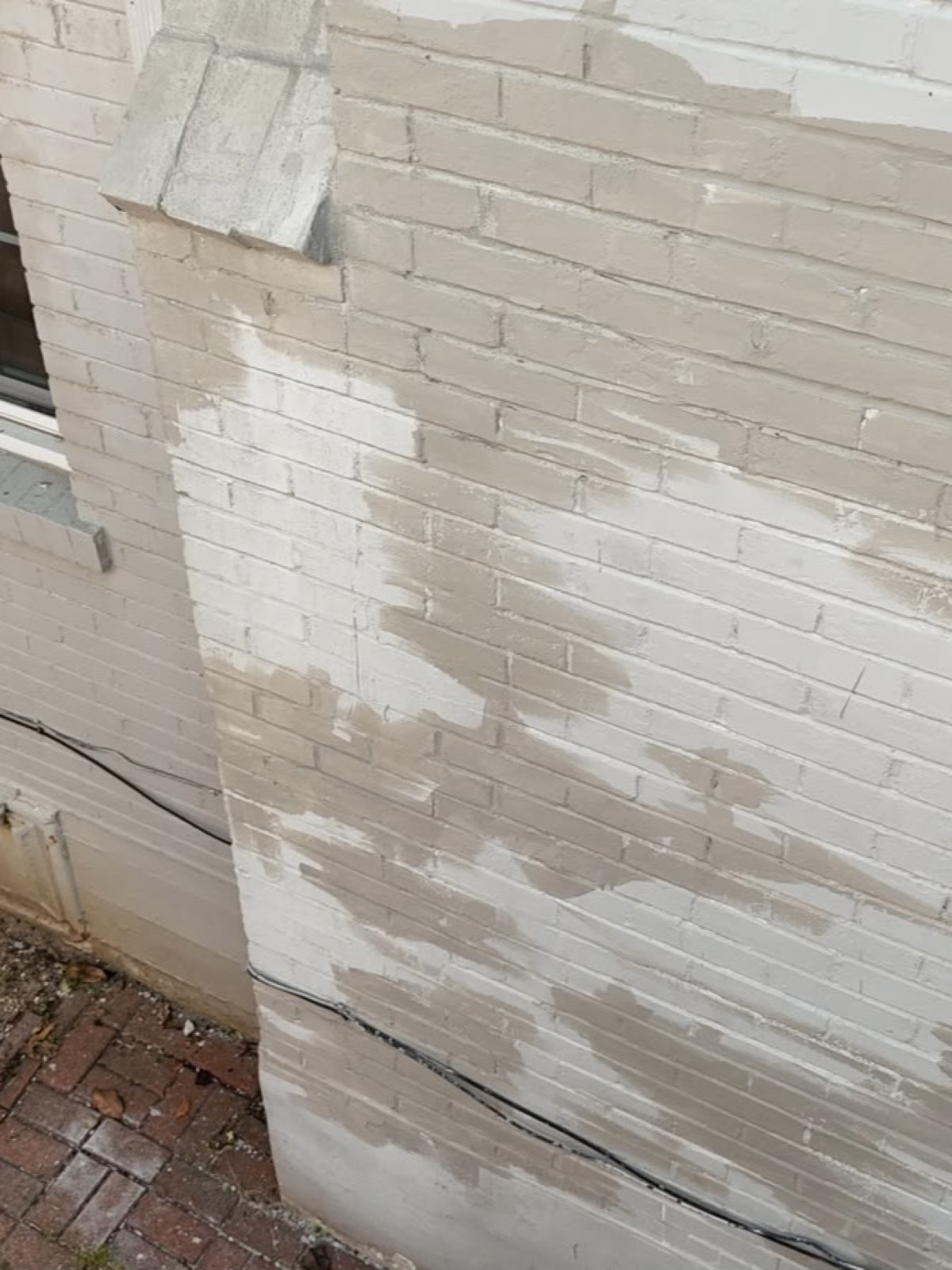 Chimney wall covered in mismatched patches of mortar and paint from earlier repairs