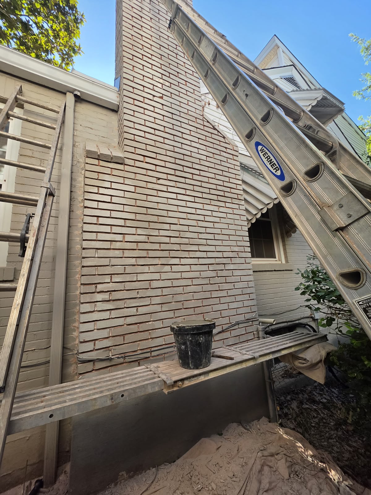 Chimney face with all of the mortar joints raked out and the brick edges exposed