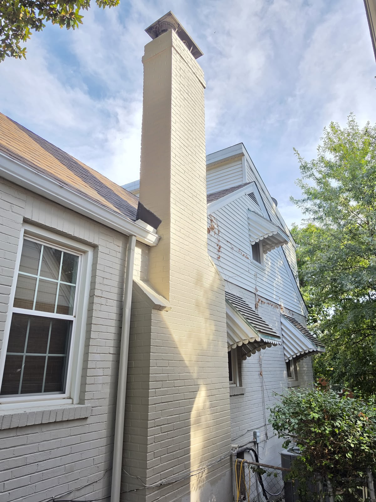 The same chimney rebuilt, repointed, sealed and repainted in one even colour