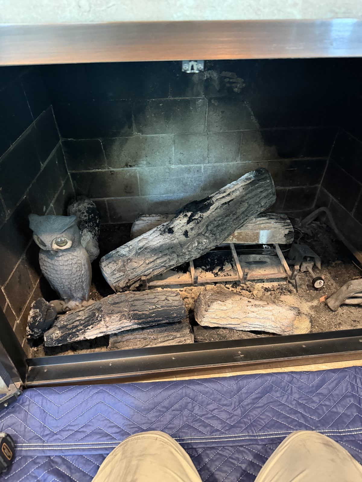 Gas fireplace before cleaning by AirPlease Missouri Chimney Services, with sooted logs and ash across the firebox