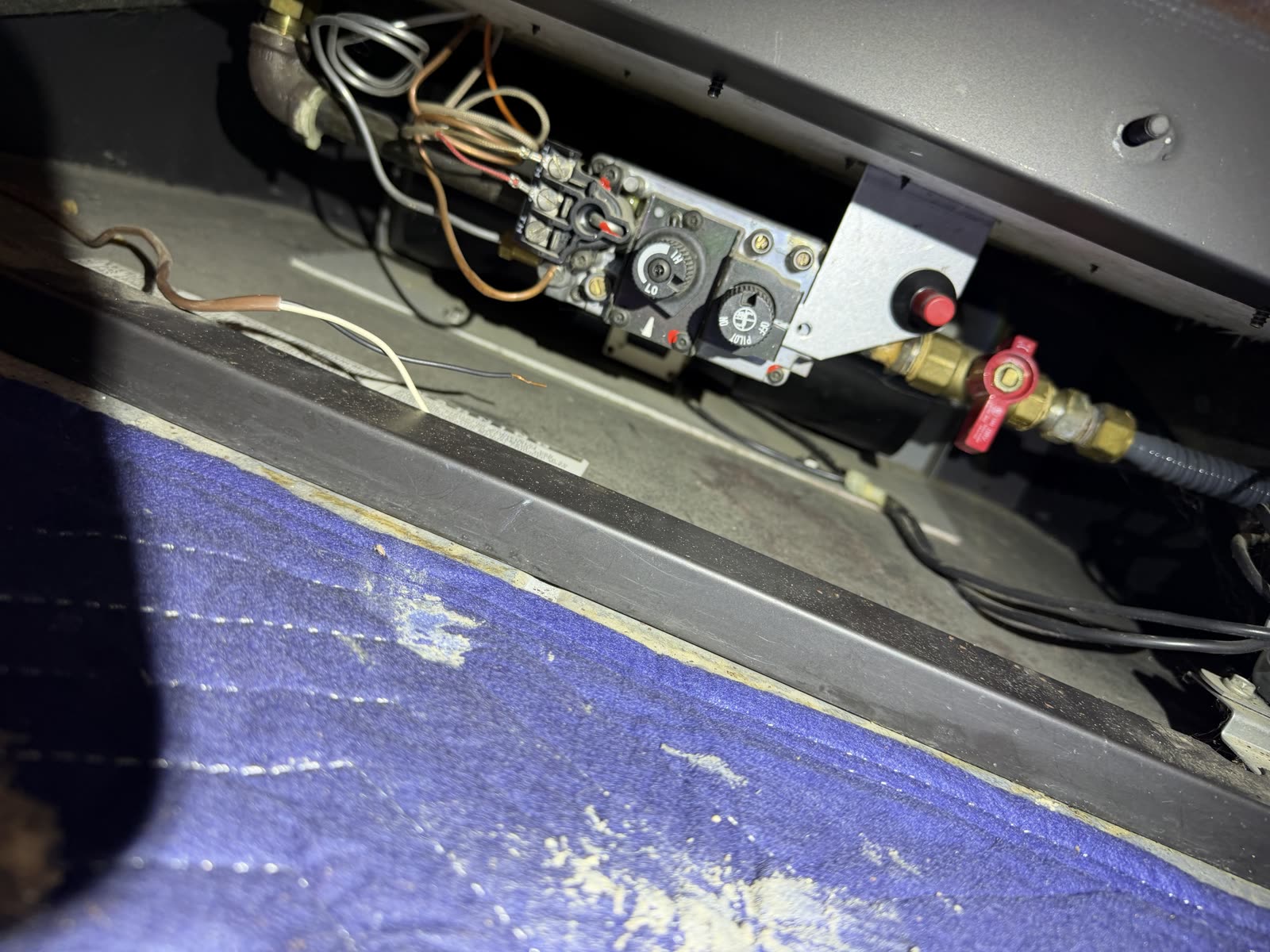The original gas valve assembly and wiring on the fireplace, examined by AirPlease Missouri Chimney Services before replacement